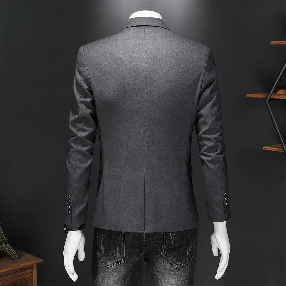 Chaqueta de vestir empresarial de pana gris oscuro con ajuste slim, textura sutil y detalles decorativos de botones en los puños.