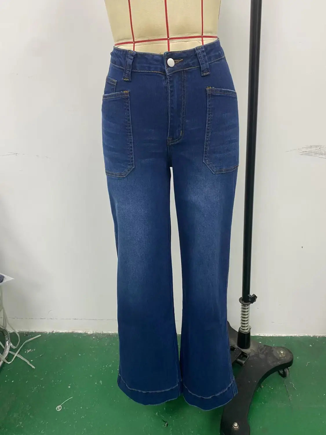 Wide leg denim pants with belt featuring blue high-waisted wide-leg jeans with front pockets and button closure.