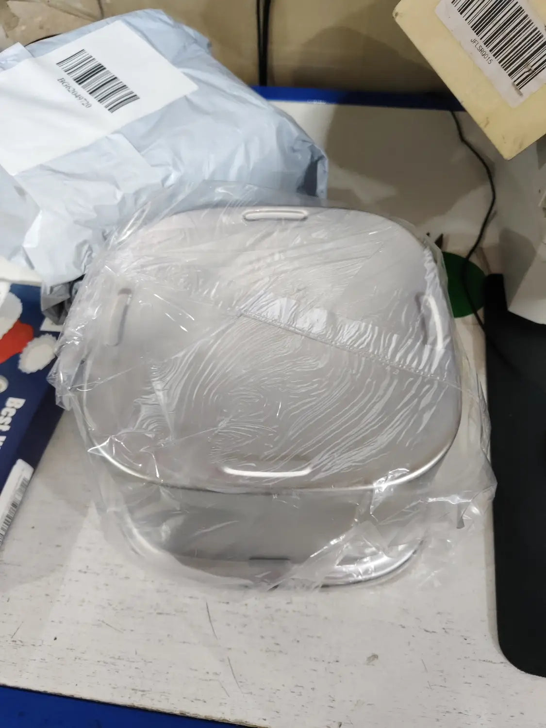 Un élégant cuiseur à riz électrique couleur argent, au design moderne et aux bords arrondis, présenté avec une gamelle flottante pour chien en acier inoxydable.