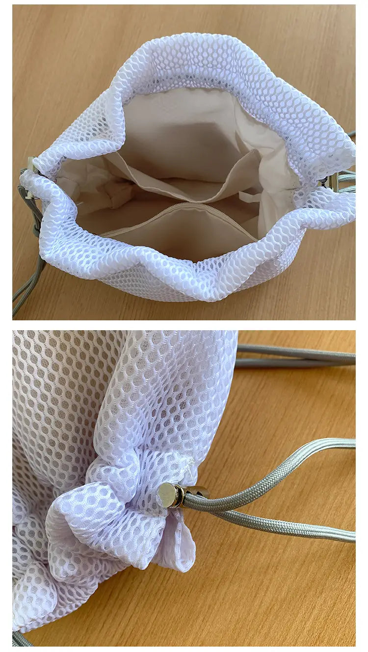 Mini pink mesh drawstring bucket bag with heart charm featuring white mesh exterior, beige interior lining, and silver-toned metal hardware.