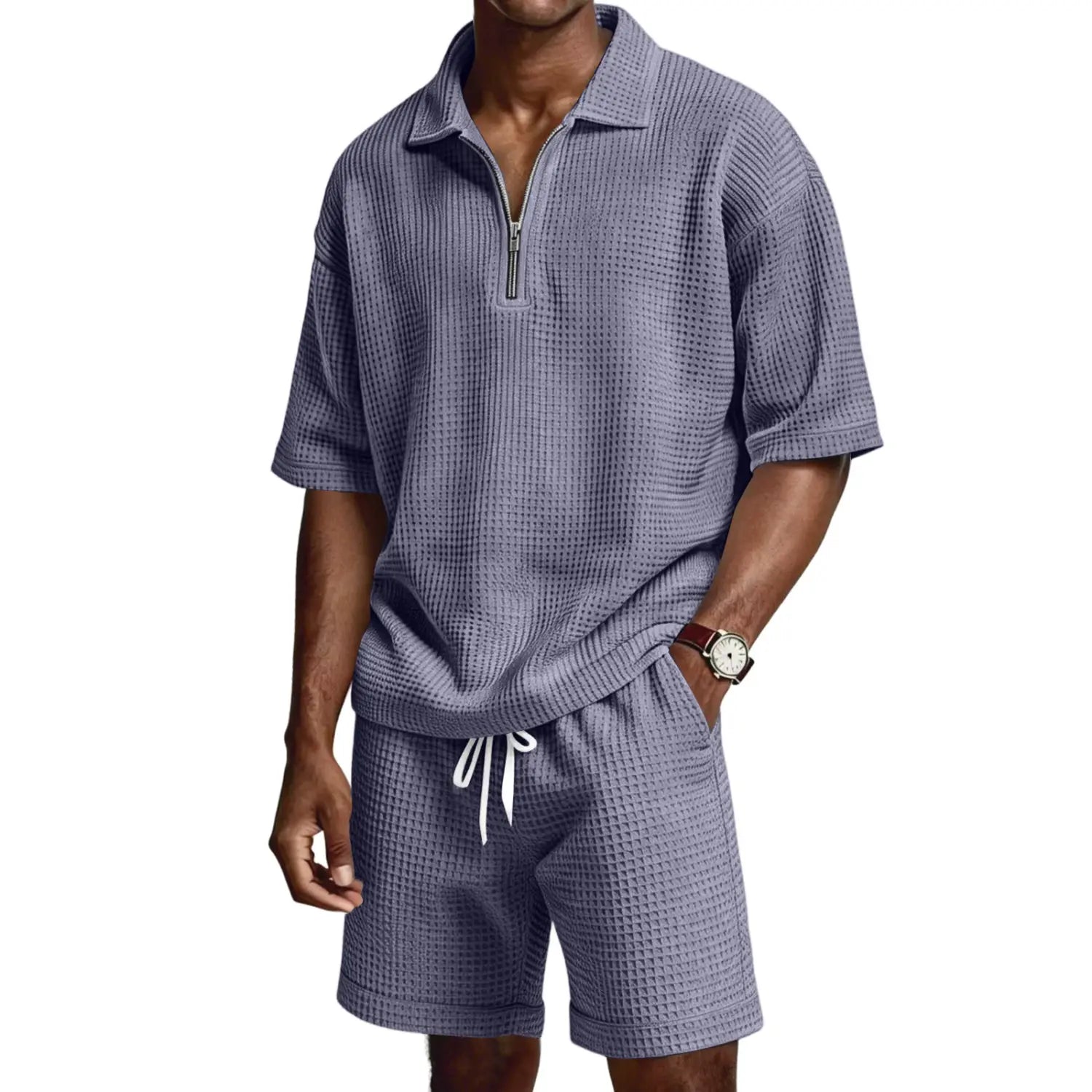Un ensemble short polo à demi-zip en maille nid d’abeilles pour homme, dans un tissu bleu sourd texturé, comprenant des manches courtes, un short et des cordons blancs.