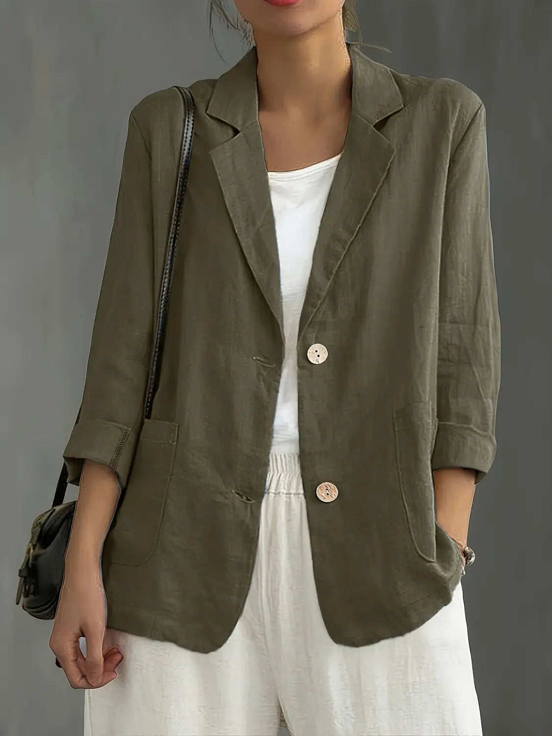 Blazer de lino color verde oliva con dos botones de color claro y mangas remangadas, diseñado para ropa de trabajo casual.