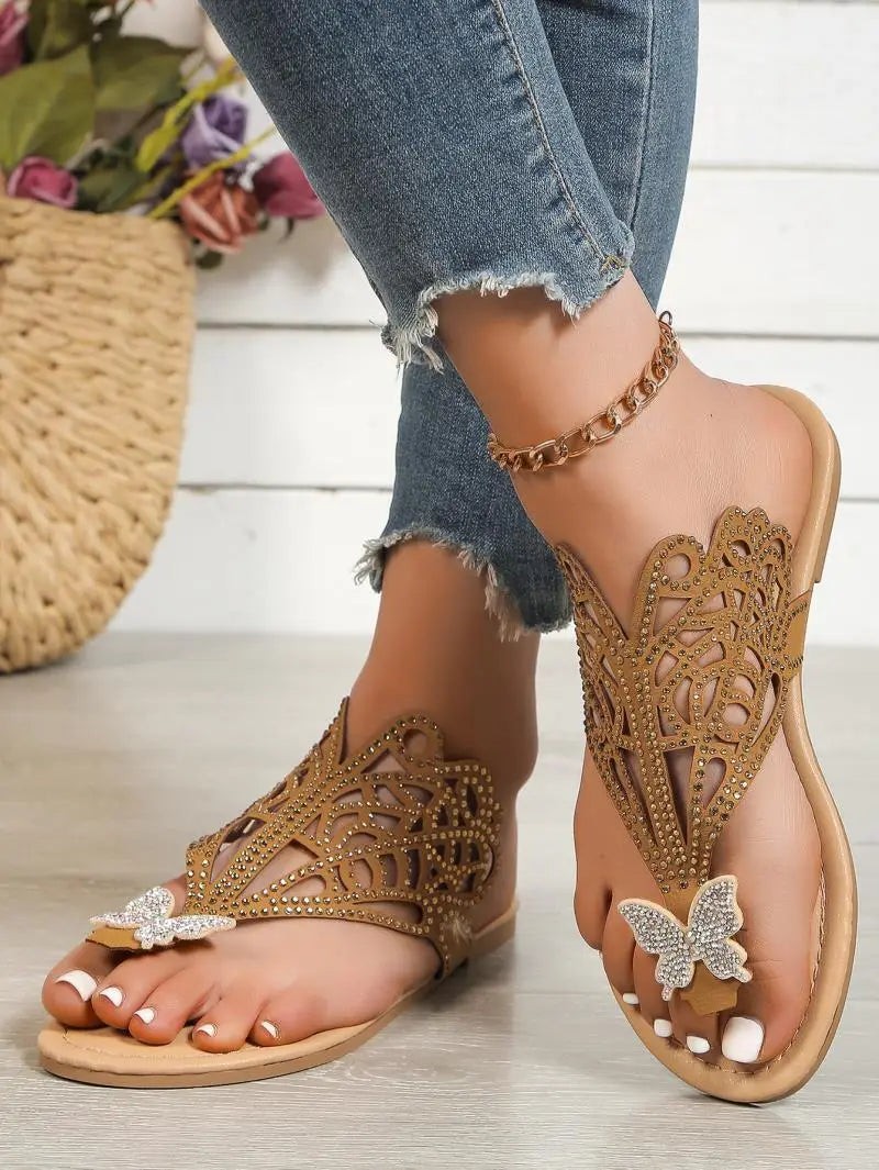 Women’s gold rhinestone hollow flat slip on sandals featuring butterfly embellishments and intricate cutout patterns.