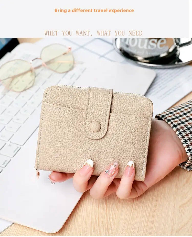 Beige textured leather mini organ wallet with a single button closure ideal for compact storage.