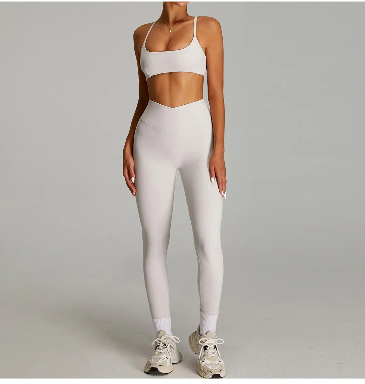 Ensemble de fitness blanc élégant à taille haute, avec un haut court et des leggings de sport sans couture à séchage rapide, conçus pour l’athleisure.