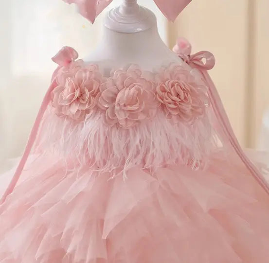 Robe de cérémonie de fille d’honneur en tulle floral rose à tutu, délicatement agrémentée d’appliqués floraux superposés et de bordures à plumes.