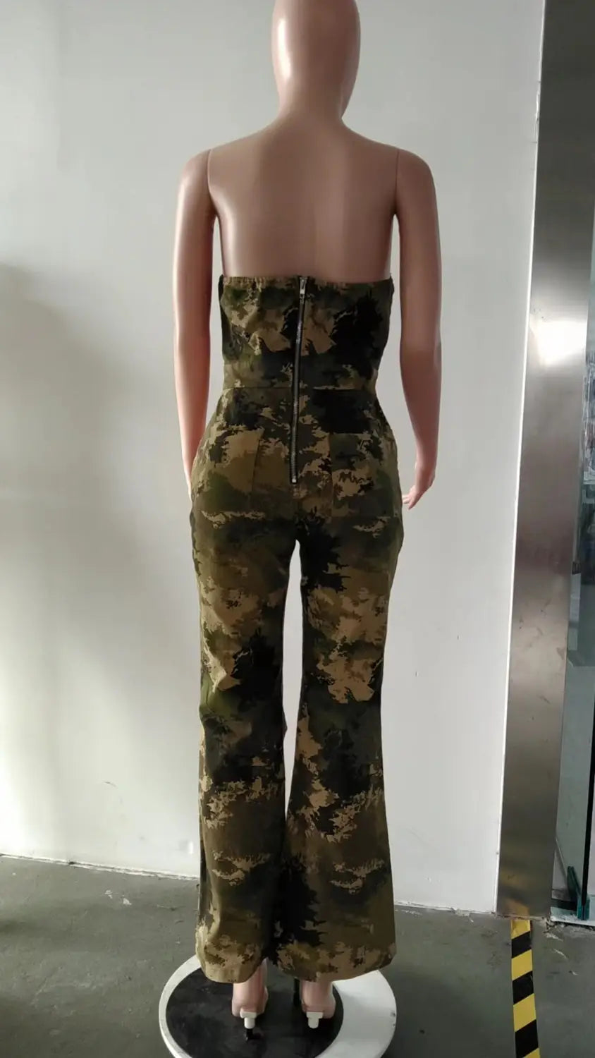 Rückansicht eines Camouflage-Aussteller-Jeansjumpsuits mit hochtailliertem Schnitt und einem zentralen Rückreißverschluss