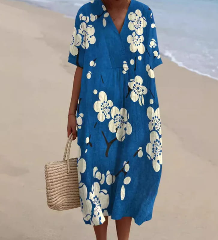 Vibrant floral v-neck short sleeve maxi dress featuring a blue lightweight fabric with white blossoms and black branches floral print.
