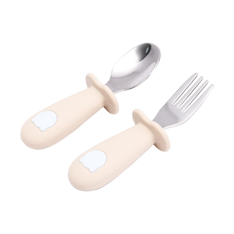 Ensemble de couverts pour bébé cuillère et fourchette en acier inoxydable avec silicone de couleur crème, avec un motif délicat de tête d’ours blanc sur les manches.
