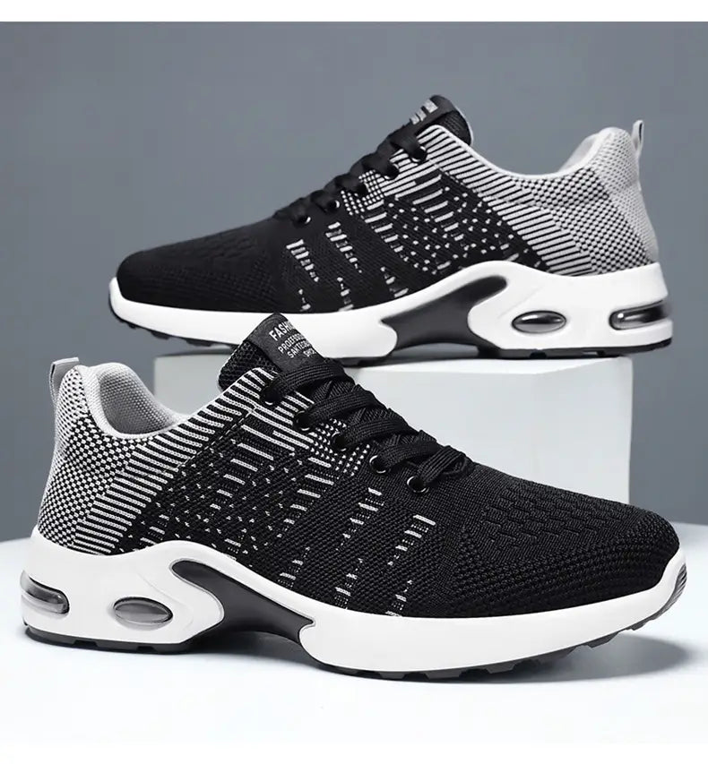Baskets décontractées pour hommes en mesh flyknit à coussin d’air, en noir et blanc, arborant un design tricot moderne respirant avec des unités d’amorti par coussin d’air visibles dans la semelle.