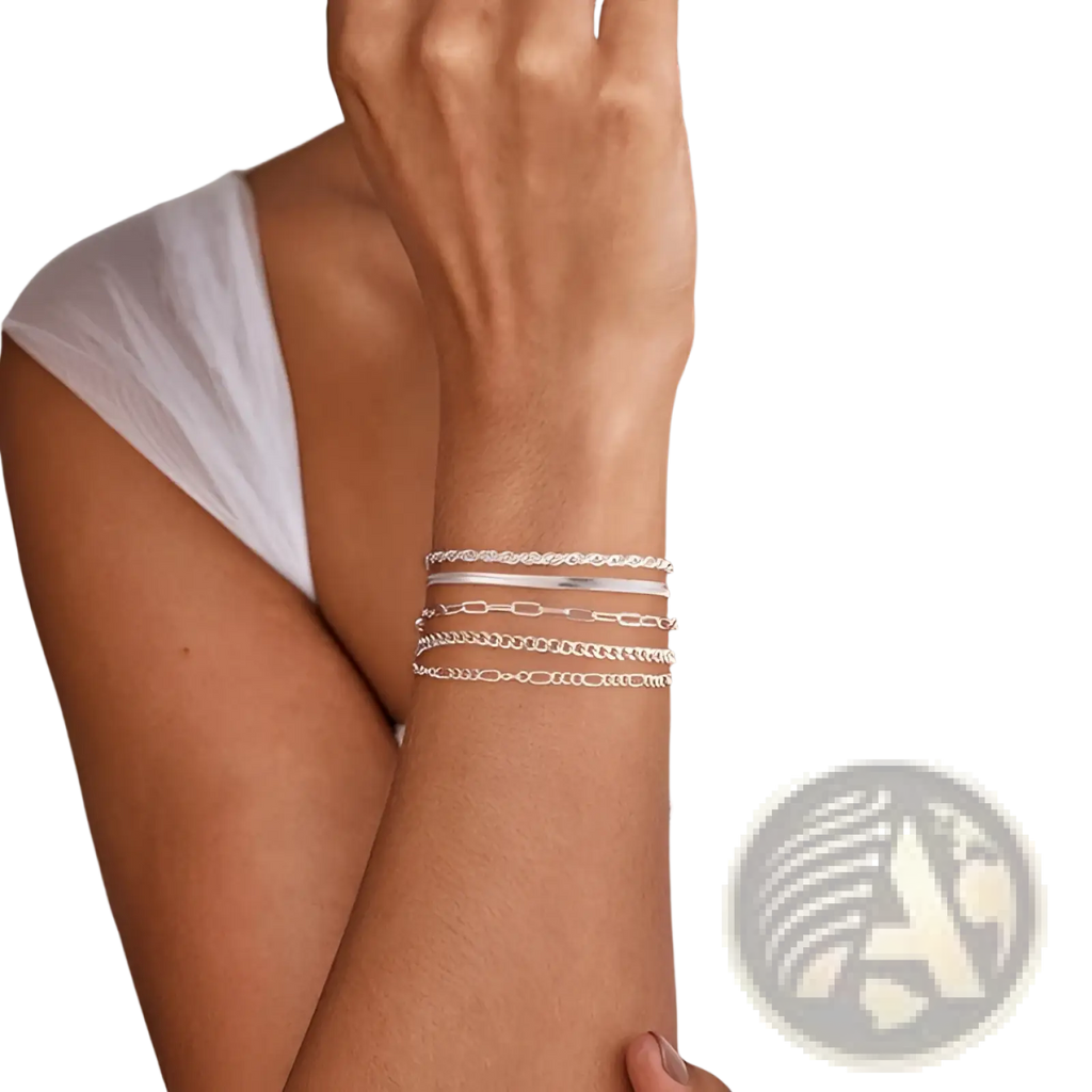 A stack of four silver toned 14k silver plated adjustable chain bracelets with varying link designs worn on a wrist