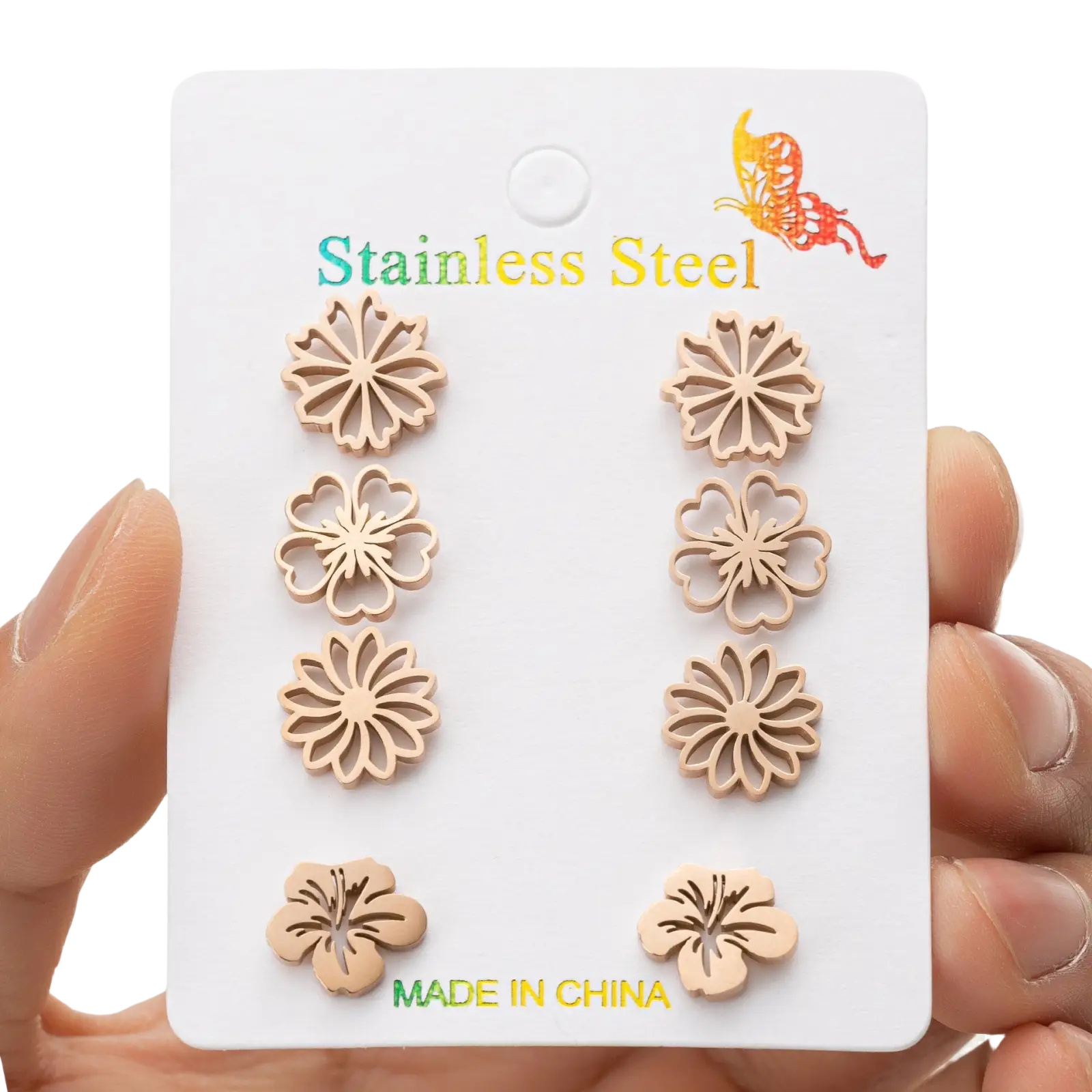 Set of six flower-shaped stainless steel stud earrings in light metallic finish displayed on a white card