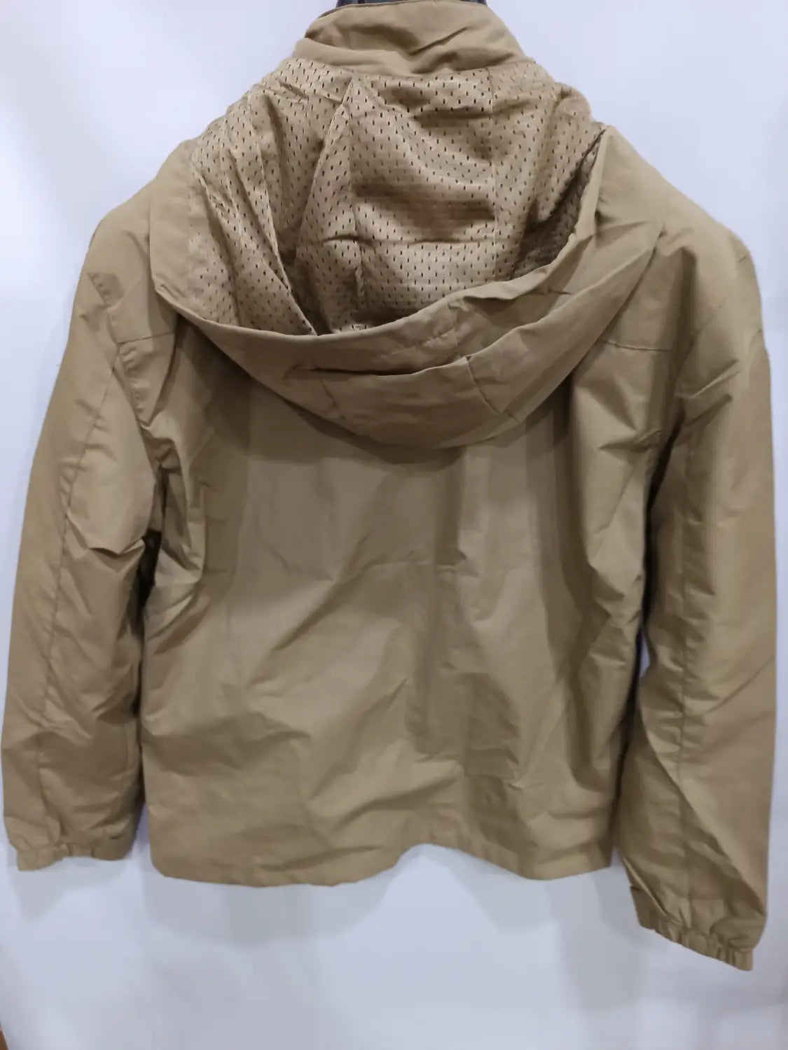Chaqueta de senderismo con capucha impermeable color camel, con forro perforado para mejorar la transpirabilidad.