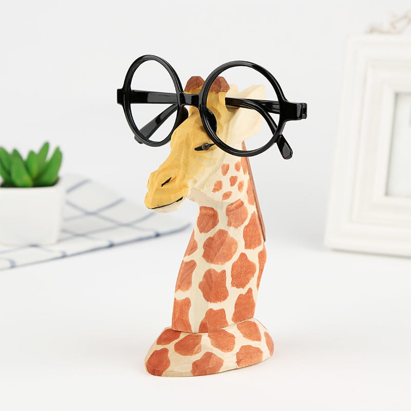 Soporte para gafas con animal de madera que presenta una silueta caprichosa de jirafa con base color crema, manchas naranjas y gafas redondas con montura negra para la decoración creativa del hogar.