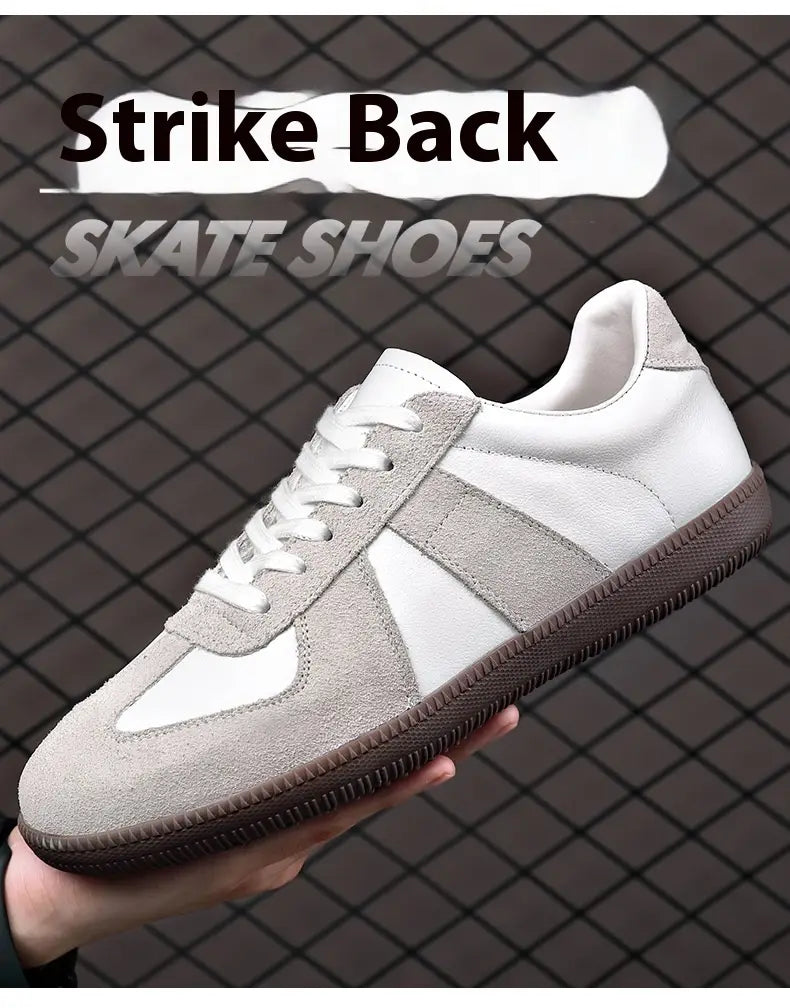 Weißes und graues Veloursleder-Schlittschuh-/Skateschuh-Modell mit brauner Gummisohle, von der Rückseite dargestellt in deutschen Trainingsschuhen Herren aus Leder und Casual-Sneakern.