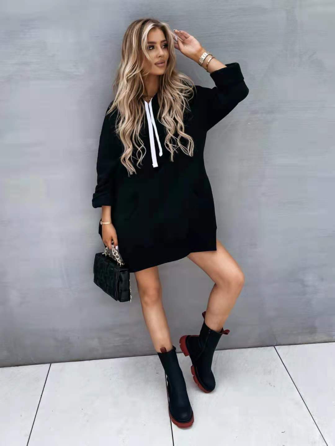 Black oversized mid length hooded sweatshirt dress with white drawstrings and pockets in cotton material suitable for casual wear.