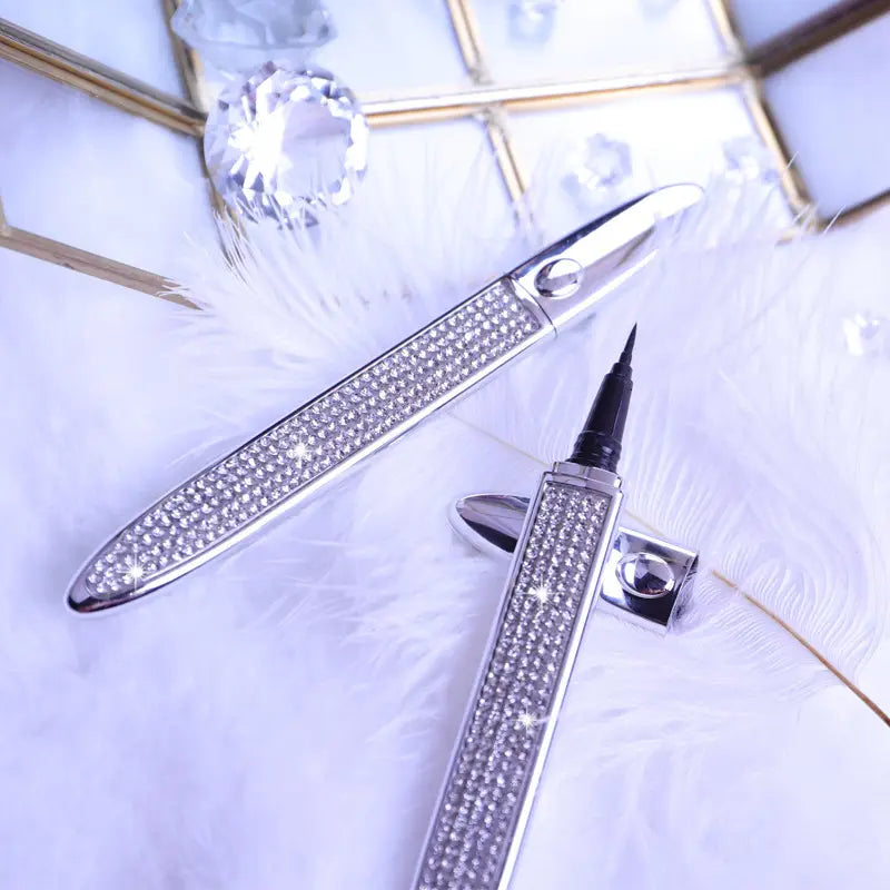 Silver rhinestone-encrusted self-adhesive eyeliner pen with a fine tip and sleek metallic finish for waterproof false lash application