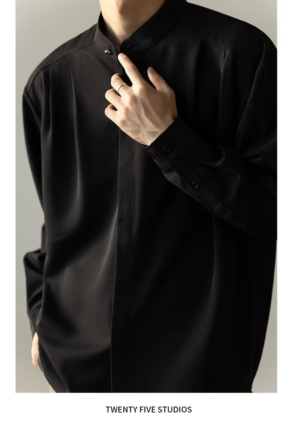 Chemise plissée pour homme à col montant en satin noir, avec manches longues, col mandarin et poignets boutonnés.