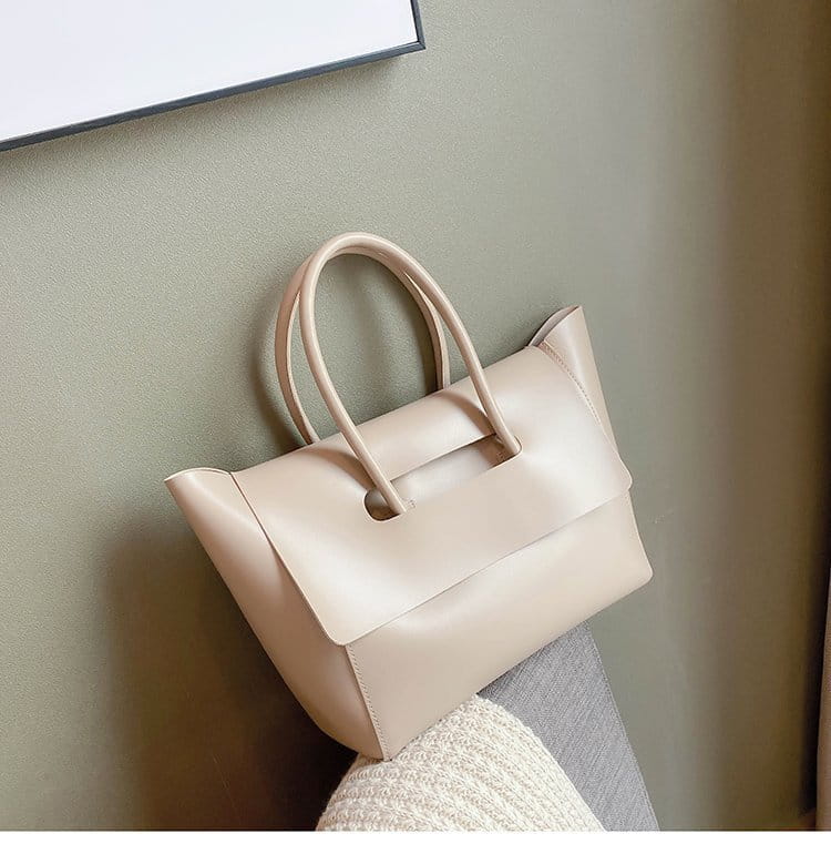 Beige leather vintage structured tote bag with rounded top handles and minimalist flap closure.
