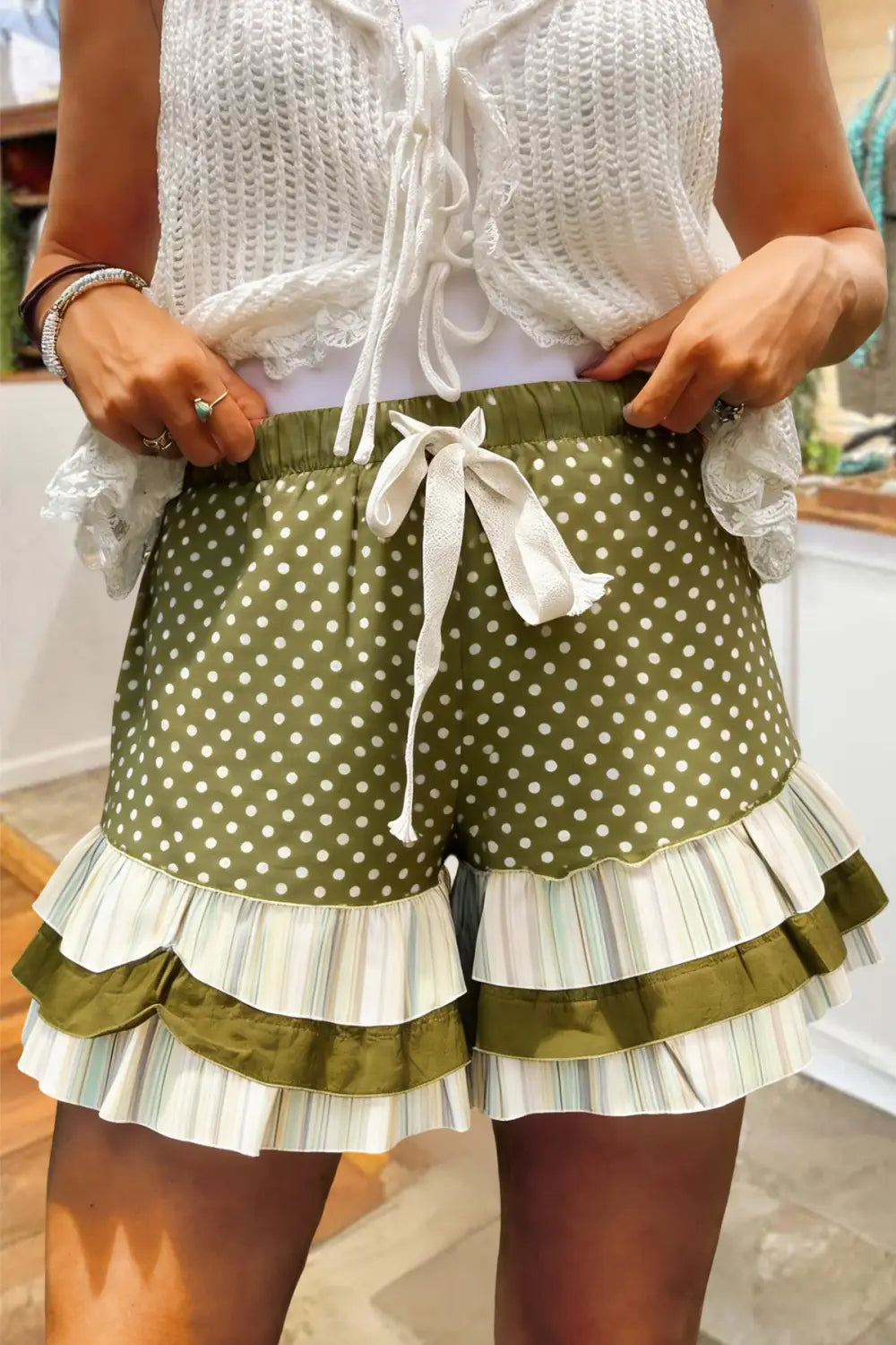 Olivgrüne Shorts mit weißen Punkten und mehrlagigen Rüschen in gestreiftem und einfarbigem Olivstoff, passend zum Design des Karomosaik-A-Linien-Rocks.
