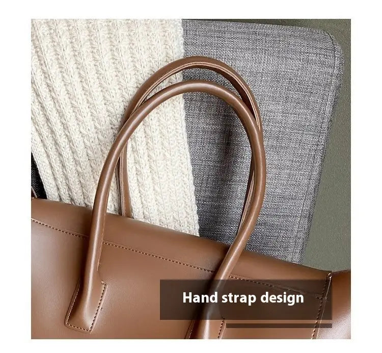 Brown leather vintage structured tote bag with curved top handles and a minimalist design.