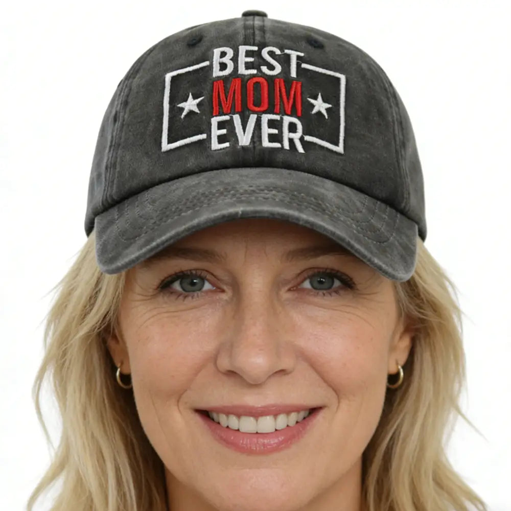 Gorra de béisbol de algodón desgastado gris oscuro con bordado en blanco y rojo que dice la mejor mamá de todas, enmarcado por un contorno rectangular y flanqueado por estrellas.