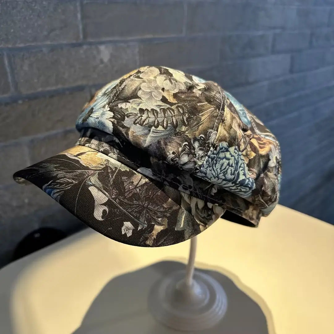 A stylish black and white floral-patterned fabric newsboy cap for women with a structured flat-top design.