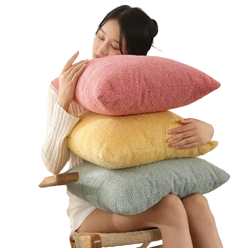 A 60x60cm cushion cover in warm coral pink made of soft teddy velvet with a solid pure color design