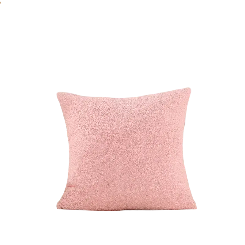 A soft pink 60x60cm cushion cover made of solid teddy velvet fabric on a beige tufted sofa for home decor