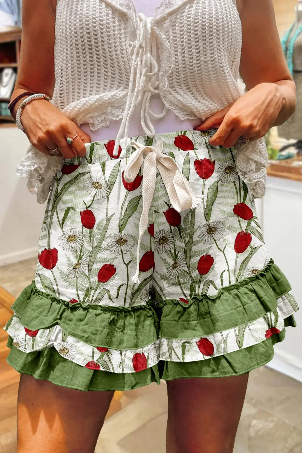 Karomosaik-A-Linien-Rock mit weißen Shorts mit einem roten Tulpen- und grünen Blattmuster sowie olivgrünen, mehrlagigen Rüschen am Saum.