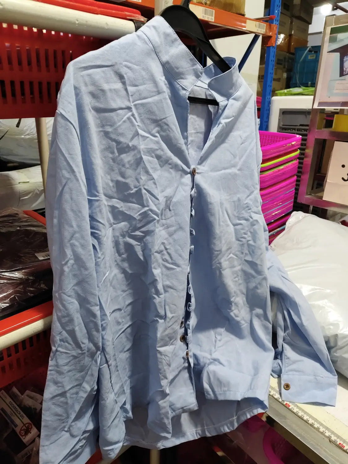 Light blue slightly wrinkled cotton button-up shirt with classic collar and front placket in a mandarin collar linen blend wrinkle resistant casual shirt design.
