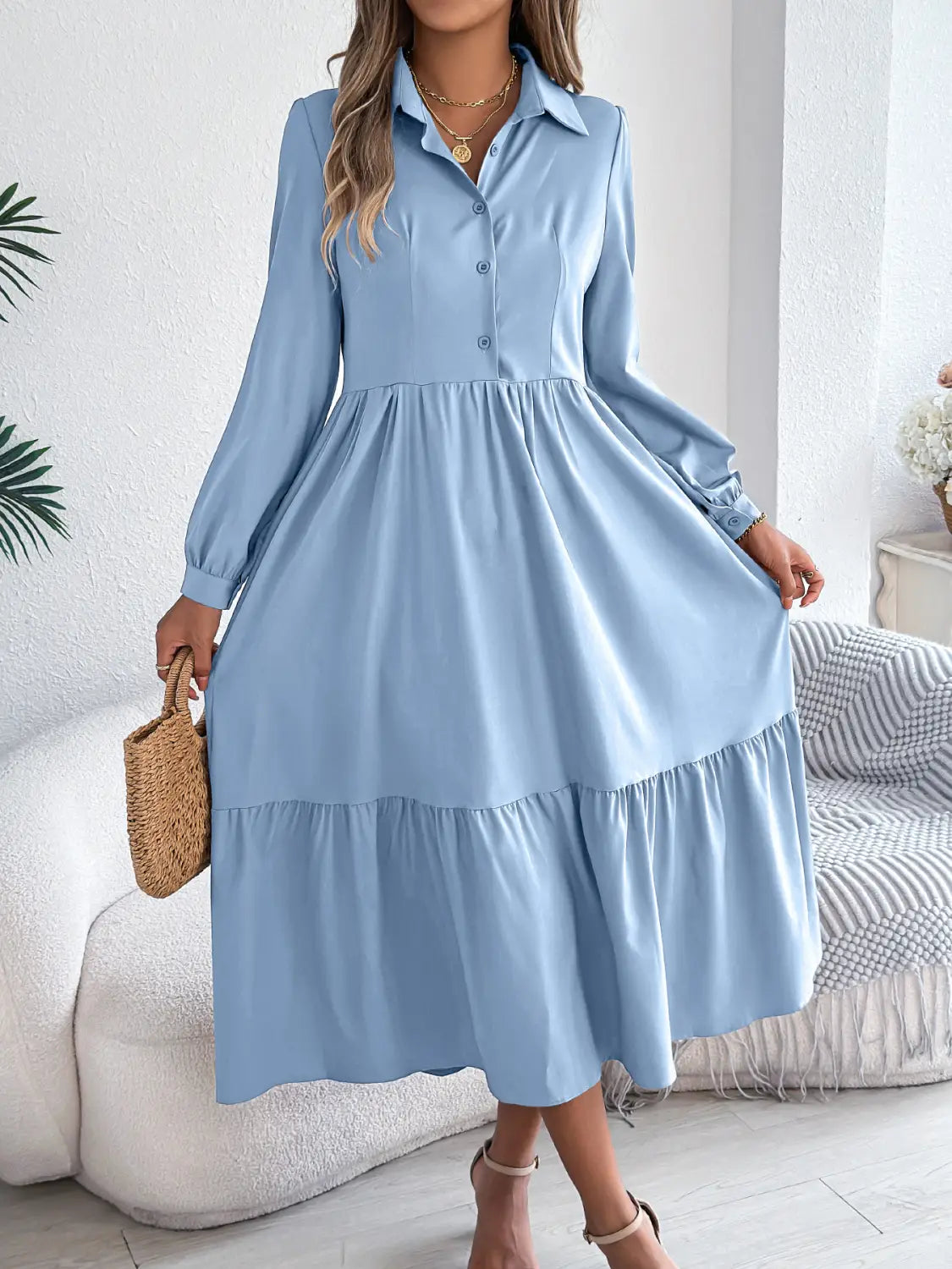 A light blue long sleeve tiered button down midi dress with a collar and a flowy skirt suitable for women.