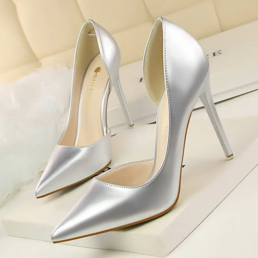 Silver satin pointed toe patent leather stiletto high heel pumps with a thin heel for elegant occasions.