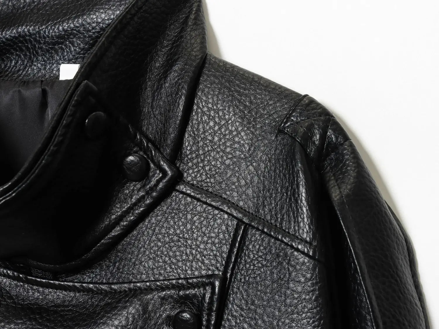 Schwarze Damen-Motorradjacke mit hohem Stehkragen aus Kunstleder mit schwarzem gepunktetem Leder und Druckknöpfen.