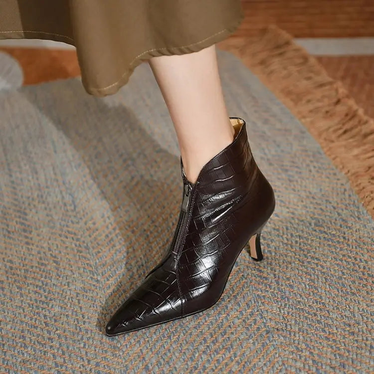 Black crocodile-embossed leather stiletto ankle boot with a pointed toe and slender heel shown from the back side.