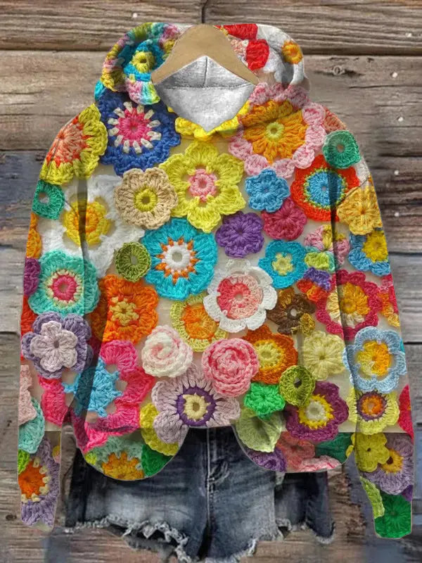 Men’s graphic print pullover hooded sweatshirt featuring a vibrant hand-crocheted design with colorful floral appliqués in a rainbow of hues and textures.