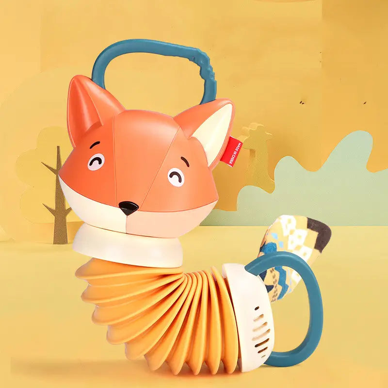 Un hochet pour bébé en forme de renard orange, doté d’un corps d’accordéon flexible et de poignées bleues, conçu comme un jouet musical pour les nourrissons.