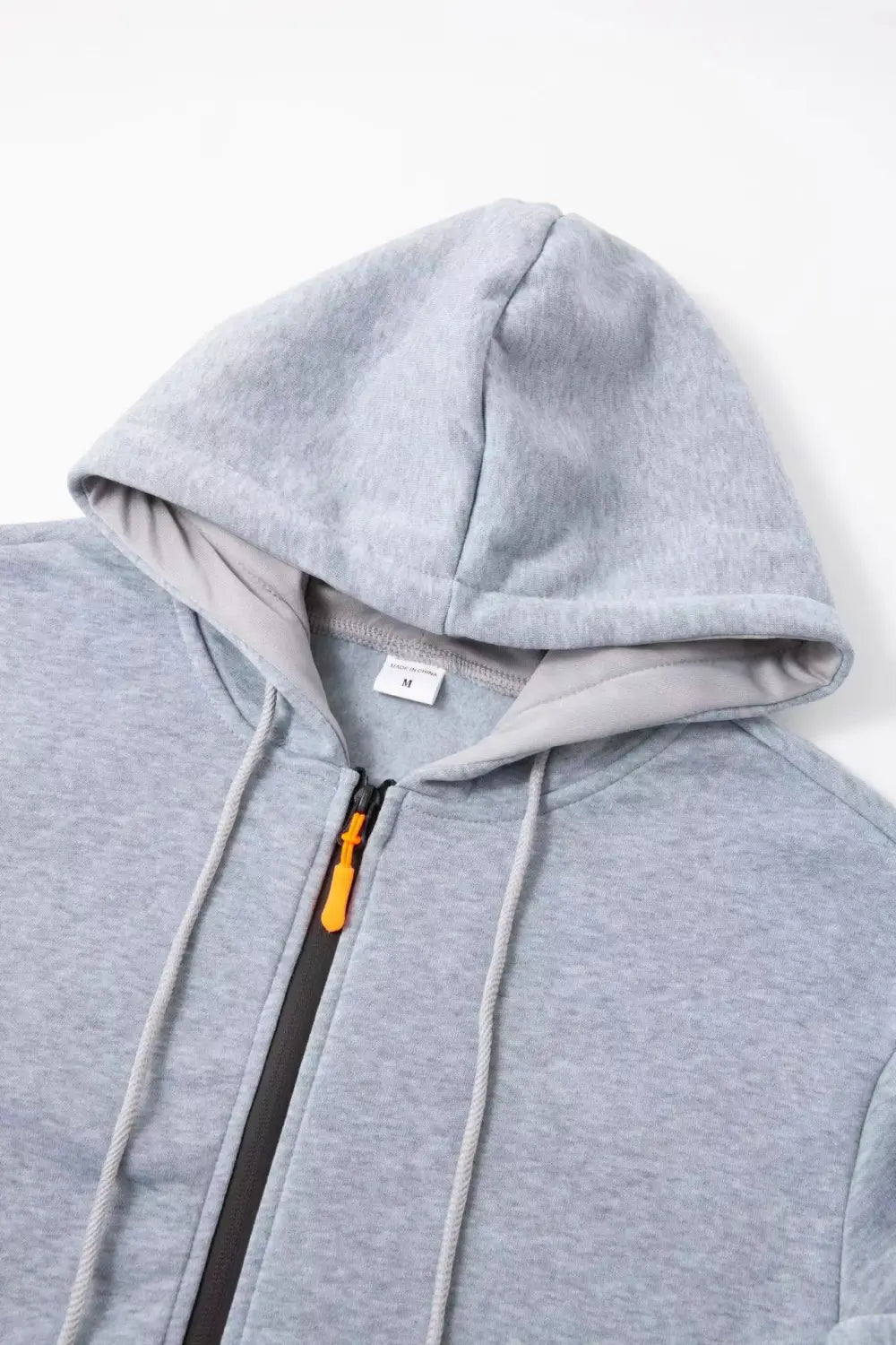 Sudadera deportiva con cierre para hombre en tallas grandes en tejido jaspeado gris, con tirador de la cremallera color naranja a contraste y cordones a juego, diseñada para uso atlético