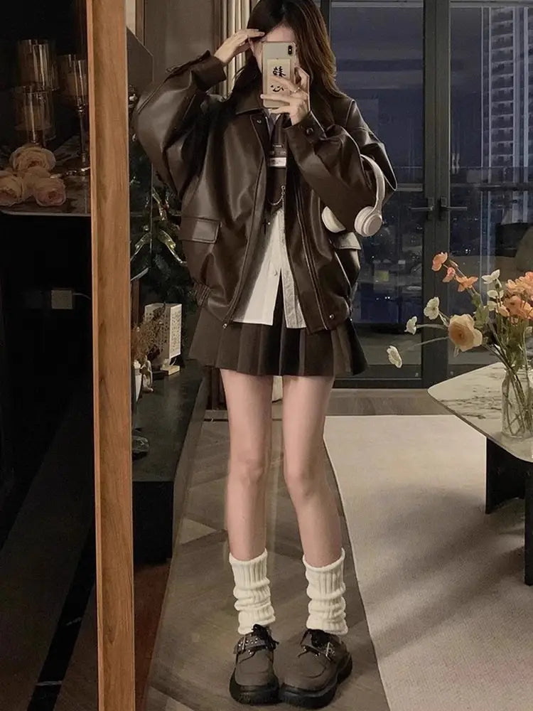 brown faux leather bomber jacket with a relaxed fit and flap pockets featured in an oversized short coat style