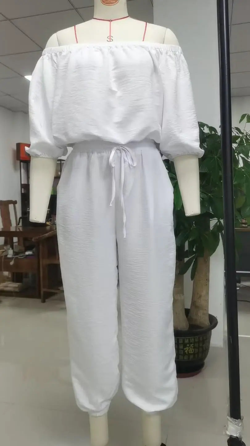 White linen off shoulder jumpsuit set with puffed sleeves and a drawstring waist.