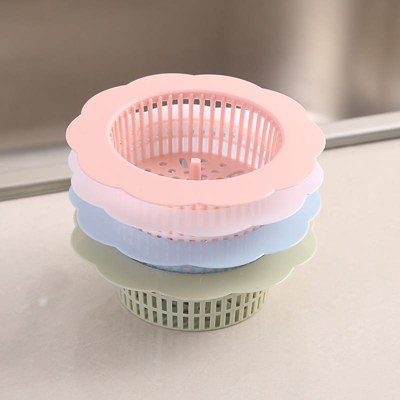 Gestapelte pastellfarbene Kunststoff-Blumen-Siphonfilter mit gezackten Rändern und perforierten Designs als Küchenablauf-Filter für den Abflussstöpsel, 4er-Pack.