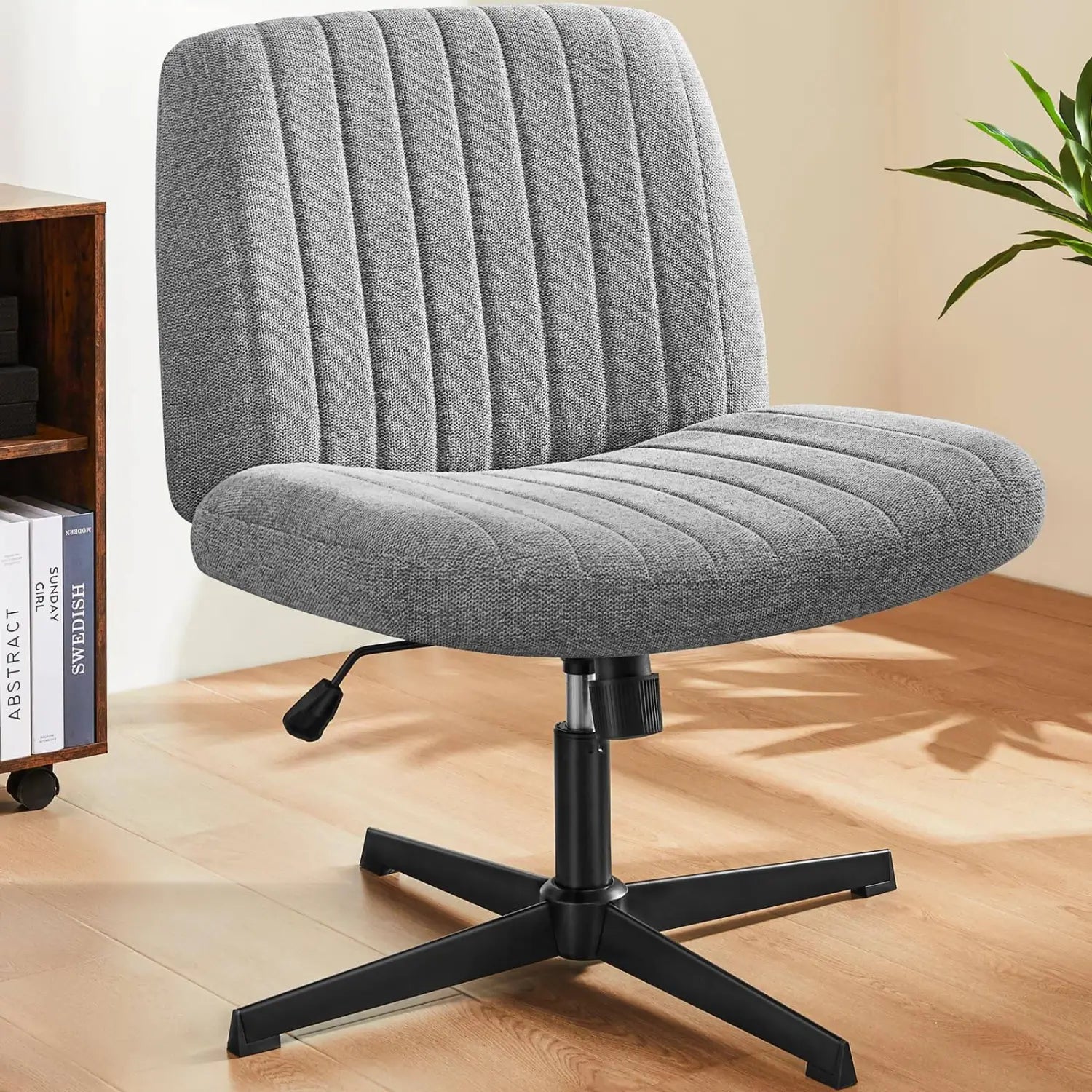 Chaise de bureau rembourrée gris, à assise croisée, avec tissu nervuré vertical et base en métal noir, conçue comme chaise de bureau pivotante large et sans accoudoirs.