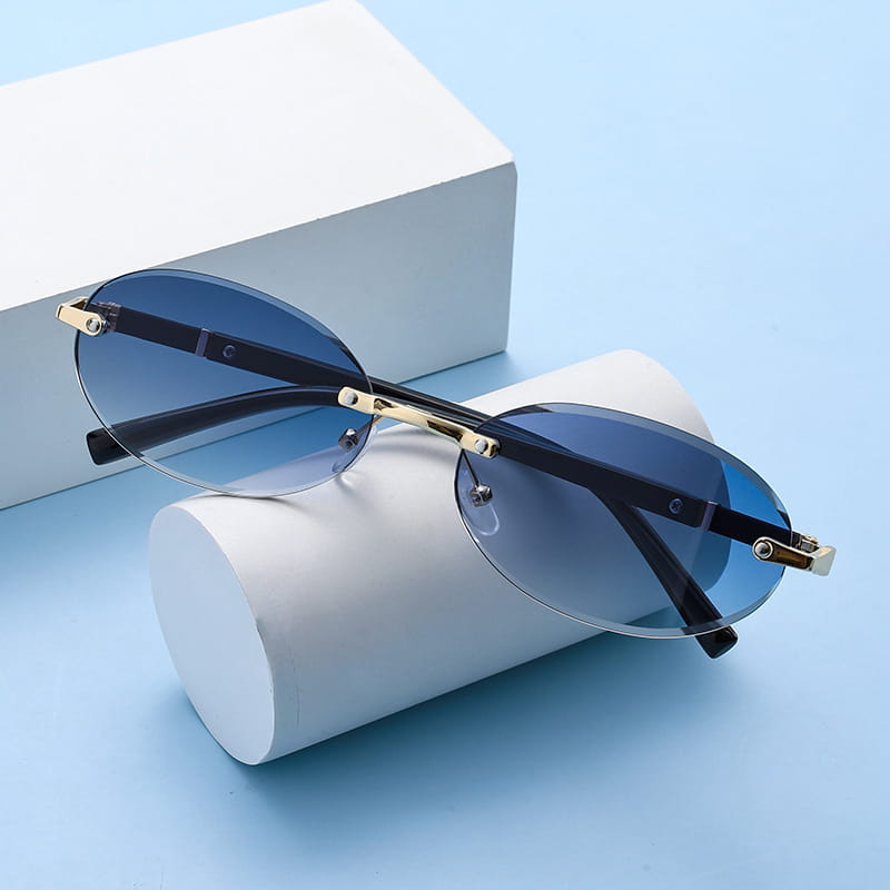 Blue gradient lens frameless oval UV400 fashion sunglasses with gold-tone metal frames and black temple arms for stylish sun protection.