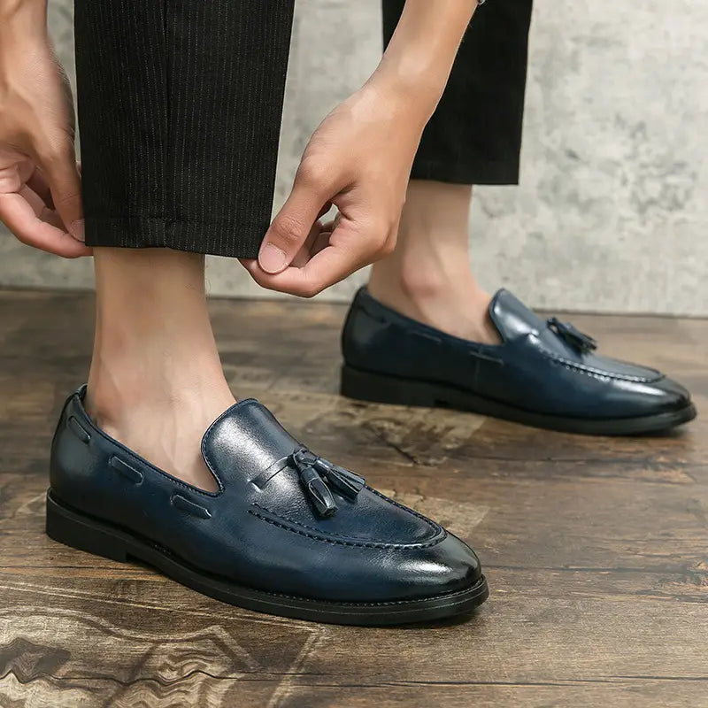 Dark blue leather tassel loafers with a polished finish and classic slip-on design.