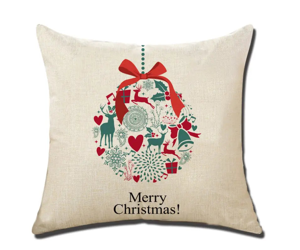 Beige linen throw pillow featuring a festive Christmas ornament design with red and green reindeer, hearts, snowflakes, and gifts tied with a bold red bow.