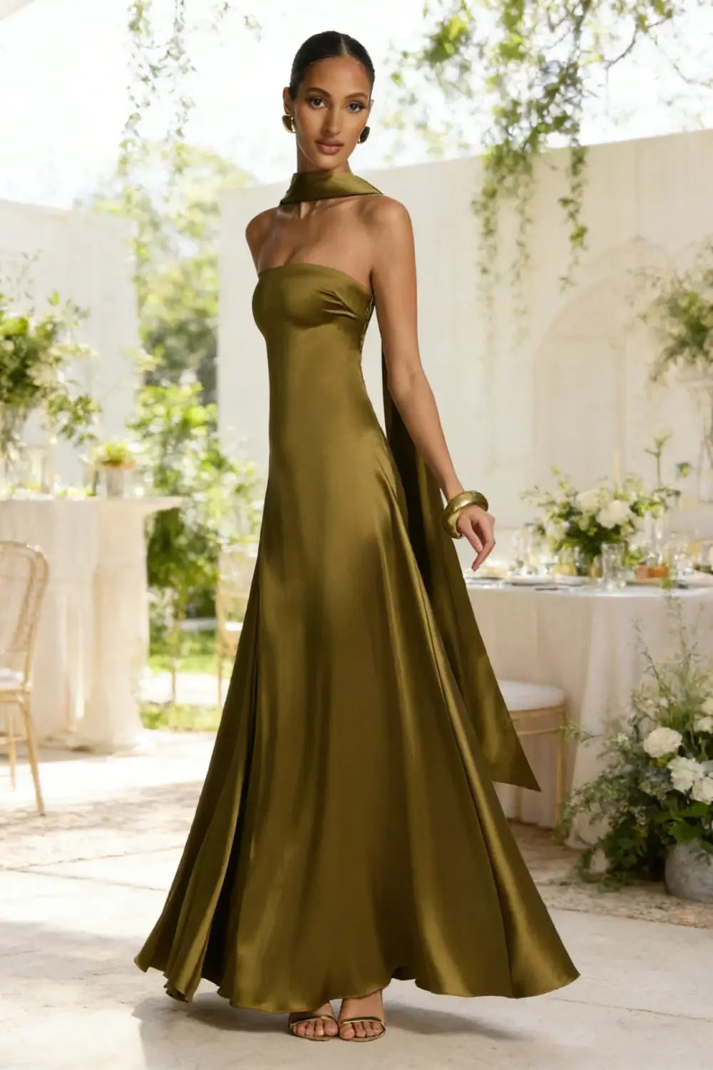 Un vestido sin tirantes de satén verde oliva, de líneas elegantes, con escote alto y silueta fluida, diseñado como vestido de noche.