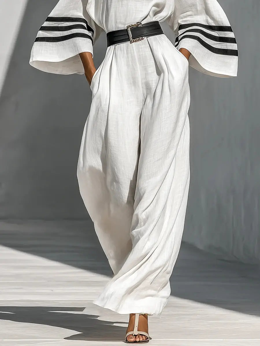 Jumpsuit mit weitem Bein aus Leinen, mit weißen Leinenhosen mit schwarzen gestreiften Manschetten und passendem Gürtel.