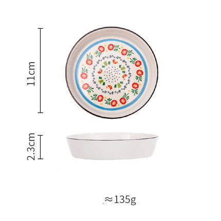 A white ceramic floral bone china round serving plate with red and green flowers arranged in concentric circles around a central dotted design bordered by blue and black lines.