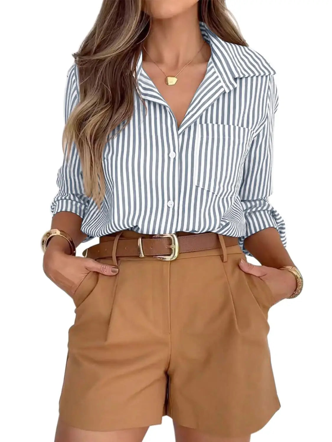 A woman wearing a women’s striped long sleeve button up shirt dress in blue and white with vertical stripes and rolled sleeves.