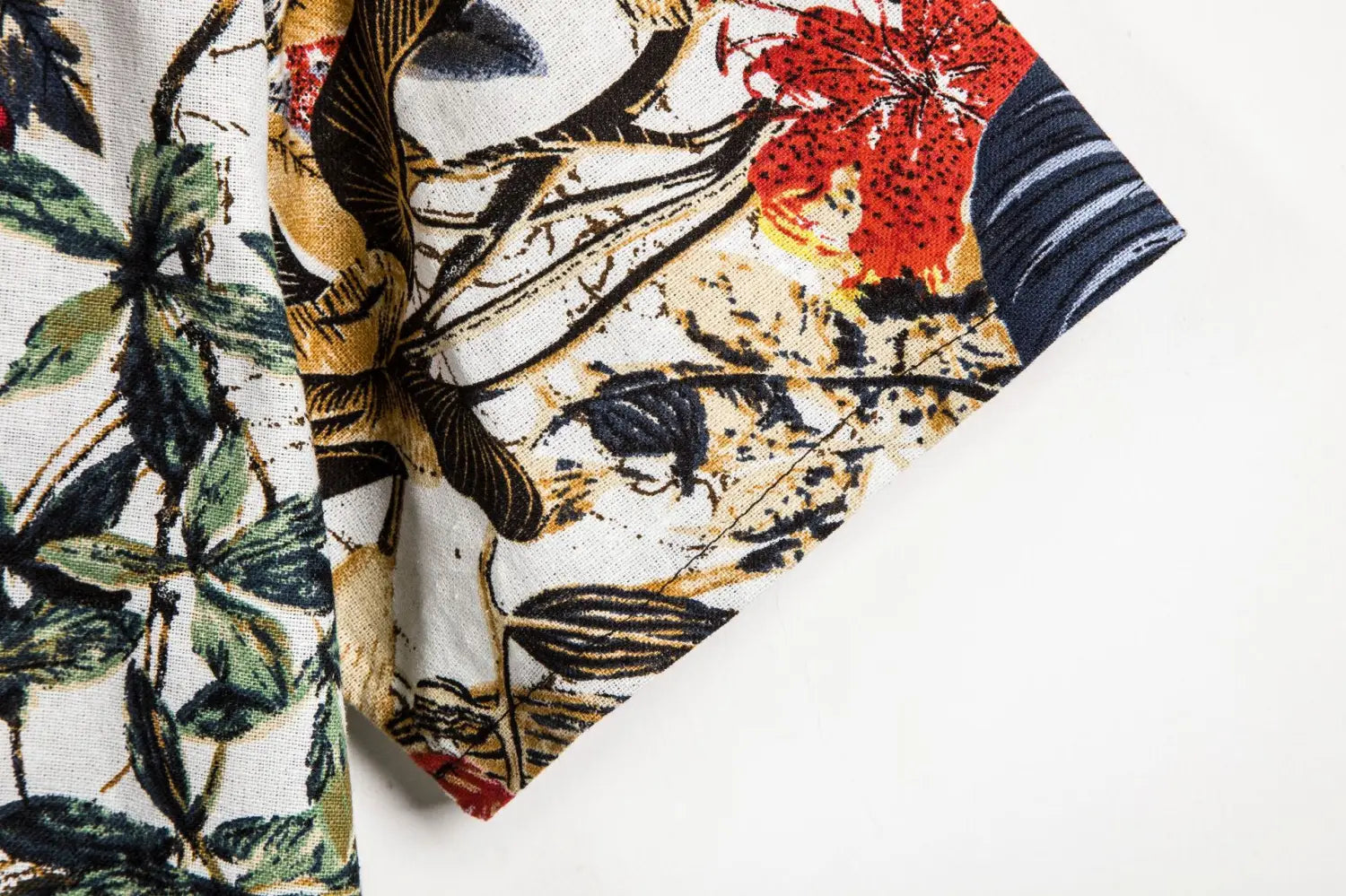 Men slim fit tropical floral short sleeve button shirt featuring a vibrant floral-patterned fabric with bold red, green, and black botanical designs on a white background.